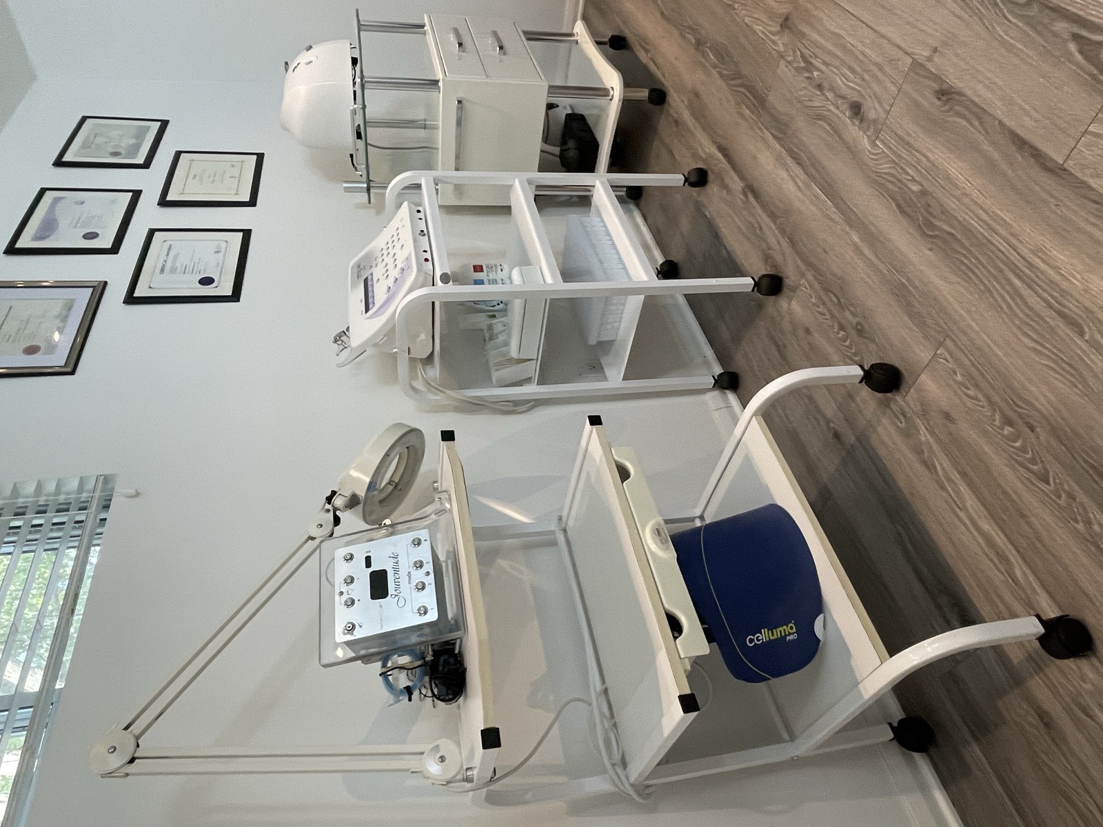 The clinic’s device wall and Badia’s certificates