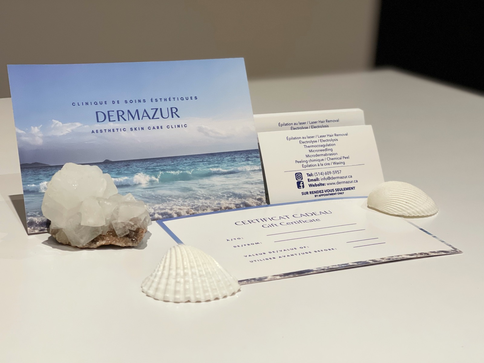 Dermazur’s printed clinic card, its business cards and a blank gift certificate, laid out on a table